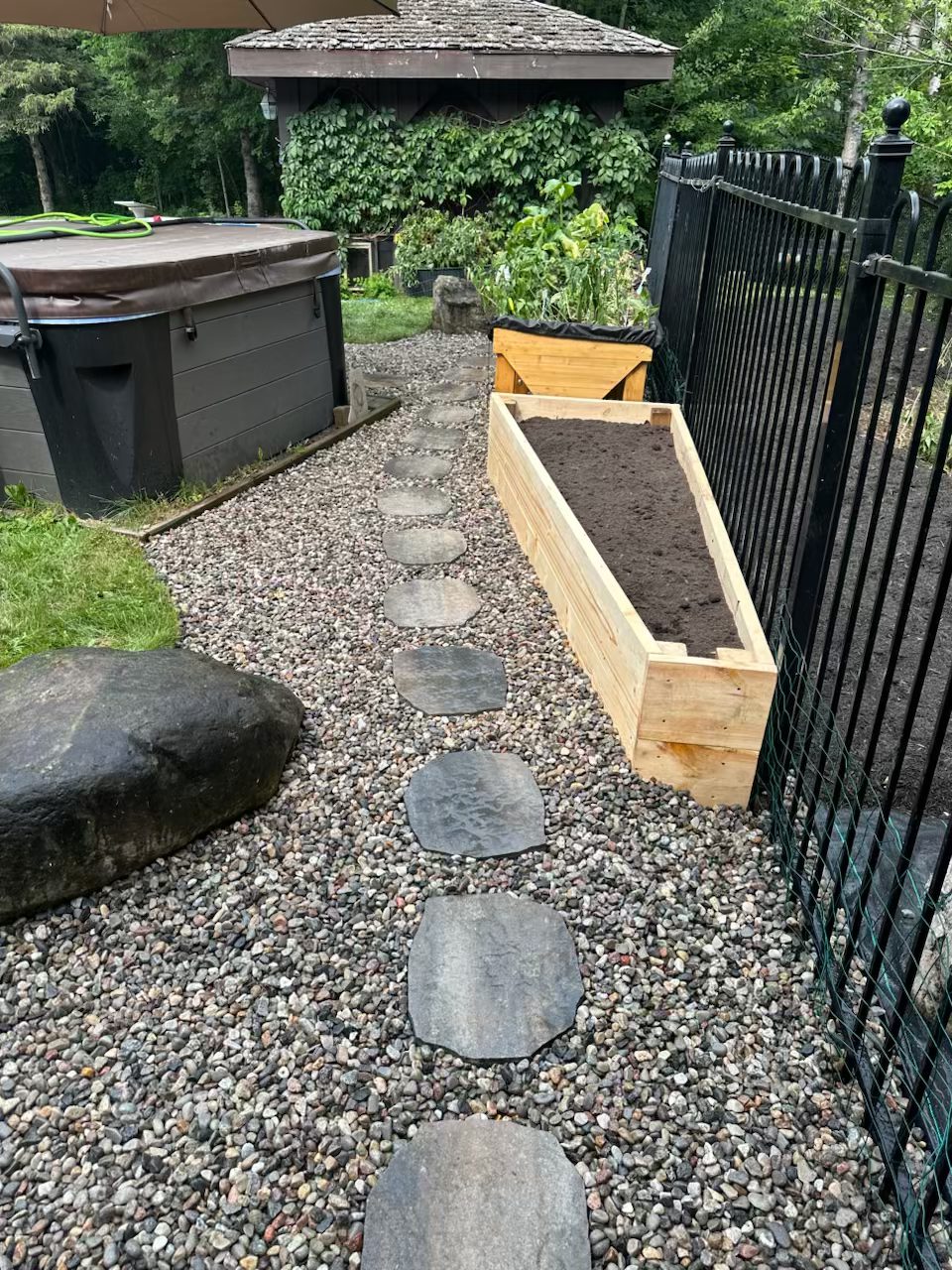 Cleaned garden bed in Margaret's Barrhaven property showing fresh soil and defined edges after overgrowth removal
